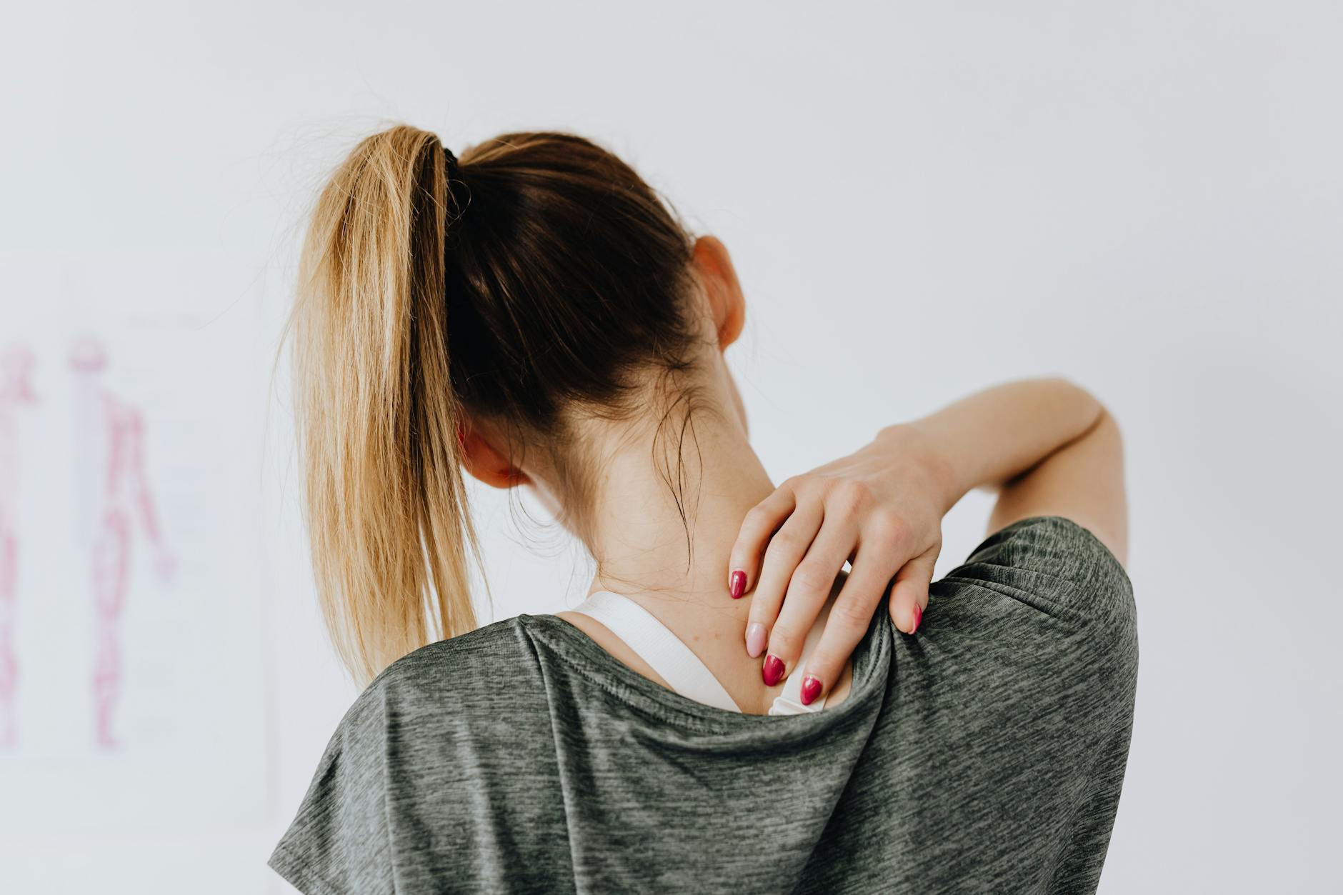 woman touching her back  A espondilite anquilosante (EA) é uma doença inflamatória crônica que acomete preferencialmente a coluna vertebral, podendo evoluir com rigidez e limitação funcional progressiva do esqueleto axial